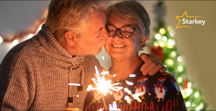 Image of senior couple holding a sparkler candle in celebration